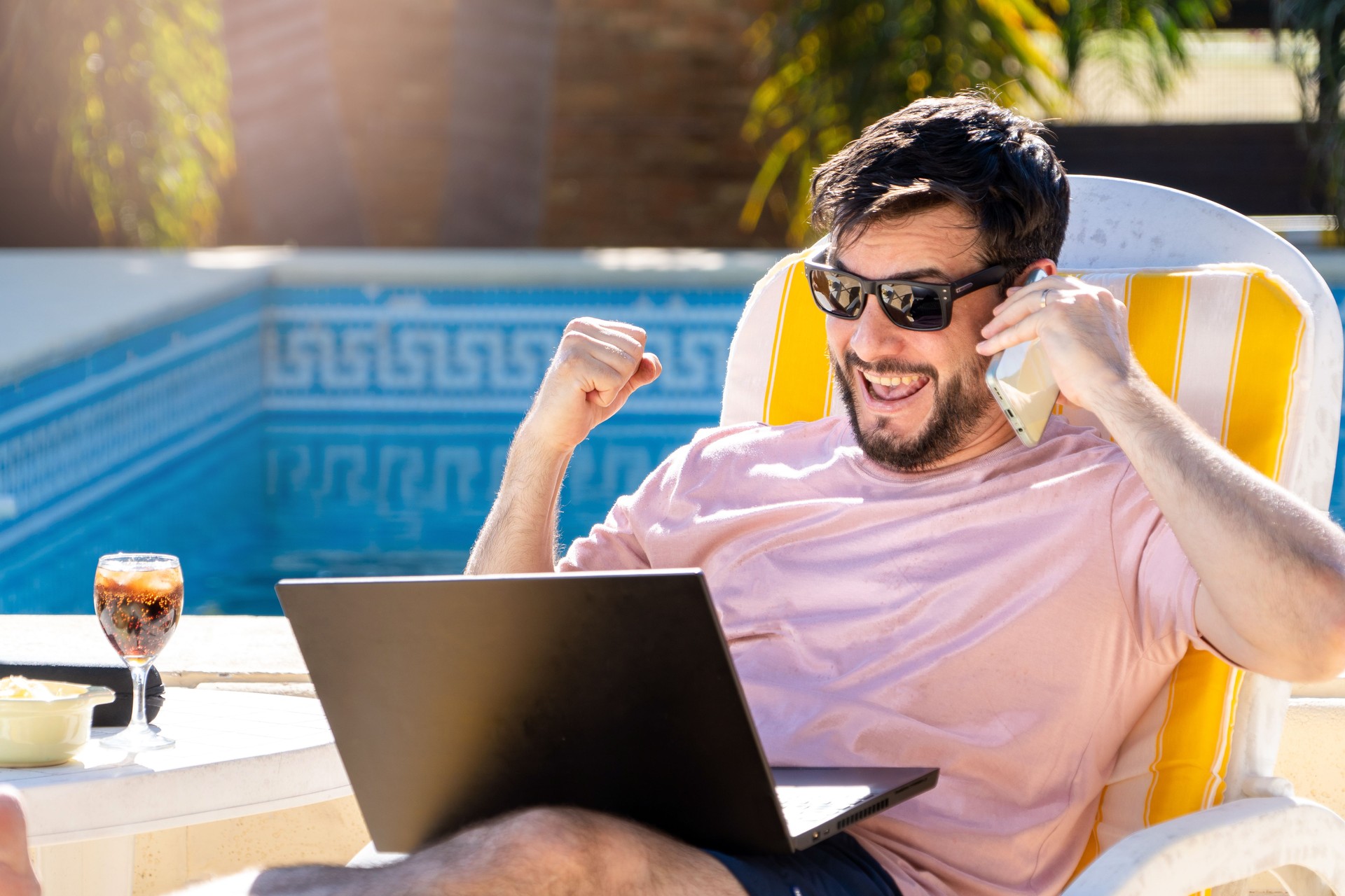 Happy man looking at his laptop and celebrating